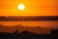 Golden and orange sunrise iluminating a hills and fields Royalty Free Stock Photo