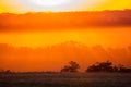 Golden and orange sunrise iluminating a hills and fields Royalty Free Stock Photo