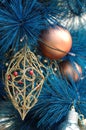 Golden ornament on blue christmas tree