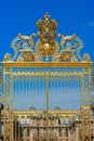 Golden ornate gates of the Palace of Versailles over blue sky. P Royalty Free Stock Photo