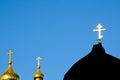 A golden Orthodox cross shines from sun against a blue sky. Christian photo with copy space Royalty Free Stock Photo