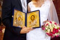 Golden Orthodox icons of The virgin and Jesus in hands of bride and groom Royalty Free Stock Photo