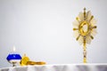 Golden Ostensory or Monstrance for Worship in a Catholic Church Ceremony with a Blue Oil Candle