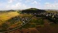 Ripe yellow rice fields surround the small mountain Royalty Free Stock Photo