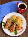 Golden pancakes in the form of roll with strawberry jam and powdered sugar Royalty Free Stock Photo