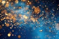 Golden particles exploding creating a festive bokeh effect on blue Royalty Free Stock Photo