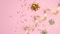 Golden party decorations, curly ribbon and confetti stars on pink background. Festive flatlay style composition for birthday, Royalty Free Stock Photo