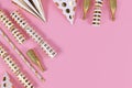 Golden party objects like hats, confetti and gifts on pink background Royalty Free Stock Photo