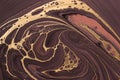 Golden pattern on brown waves and curls. Acrylic Fluid Art. Abstract background or texture