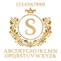 Golden patterned letters and numbers with initial monogram in coat of arms form. Shining font and elements kit for logo design