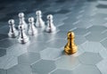 The golden pawn chess piece standing out from the group of silver pawn chess pieces on hexagon pattern floor background.