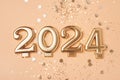 Golden 2024 on a peach color background.