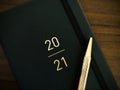 Golden pen lying on 2021 new year`s diary. Top view, close up. Royalty Free Stock Photo