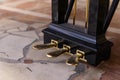 golden piano pedals of a concert grand piano standing on concert stage