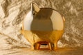 Golden pig money box on a gold background concept for financial insurance, protection, safe investment or banking