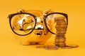 Golden piggy bank wearing glasses with money towers. Stack of euro coins near golden money box. Money pig, money saving, moneybox Royalty Free Stock Photo