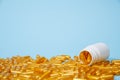 Golden pill capsules on blue background