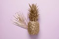 Golden pineapple and palm leaf on pink background Royalty Free Stock Photo