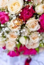 Golden wedding rings on wedding bouquet of pale pink and crimson or red roses Royalty Free Stock Photo