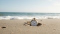 Golden pocket watch half buried in beach sand ocean waves approaching Royalty Free Stock Photo