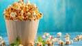 Golden popcorn in a rustic paper cup with fresh mint leaves on blue background Royalty Free Stock Photo