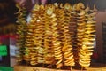 Golden potato chips on a thin wooden stick. Close up. Food background Royalty Free Stock Photo