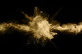 Golden powder explosion on black background.