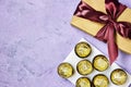 golden premium chocolate sweets with box gift isolated on purple background