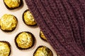 Golden premium chocolate sweets under woolen winter scarf.