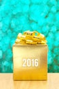 Golden Present box with 2016 word year at green bokeh light back Royalty Free Stock Photo