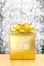 Golden Present box with 2016 word year at silver bokeh light background, Leave space for adding your text. Royalty Free Stock Photo