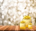 Golden present on wood table top with blur sparkling gold bokeh Royalty Free Stock Photo