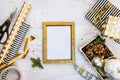 Golden ptoto frame, gift boxes, a crate full of pine cones and christmas toys and wrapping materials on a white wood old backgroun Royalty Free Stock Photo