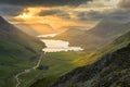 Golden Rays Of Light With Moody Clouds Over Buttermere And Crummock Water In The Lake District, UK.