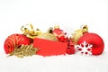 Golden,red christmas decoration on snow with wishes card Royalty Free Stock Photo