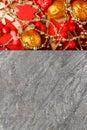 Golden and red New Year tree toys on grey stone background with copyspace. Christmas composition Royalty Free Stock Photo