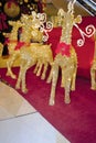 Golden reindeers near Christmas tree and gifts