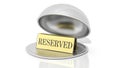 Golden reservation sign inside open serving dome dish