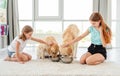 Golden retrievers drinking water next to girls