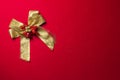 Golden ribbon bow with decorations on red flannel background Royalty Free Stock Photo