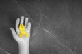 Golden ribbon childhood symbol in male hands