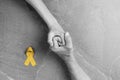 Golden ribbon childhood symbol in male hands