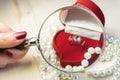 Golden ring with gem in a red gift box with pearls Royalty Free Stock Photo