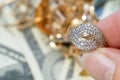 golden ring in hand, jewelry scrap of gold and silver and money, pawnshop concept jeweler looking at jewelry through magnifying Royalty Free Stock Photo