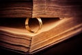 Golden ring between the pages of old book in vintage style
