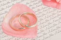 Golden rings on pink rose petal with love letter Royalty Free Stock Photo