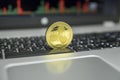 Golden Ripple coin on a black keyboard of silver laptop and diagram chart graph on a screen as a background. Virtual Royalty Free Stock Photo