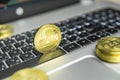 Golden Ripple coin with gold coins lying around on a black keyboard of silver laptop and diagram chart graph on a screen Royalty Free Stock Photo