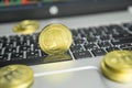 Golden Ripple coin with gold coins lying around on a black keyboard of silver laptop and diagram chart graph on a screen Royalty Free Stock Photo