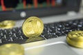 Golden Ripple coin with gold coins lying around on a black keyboard of silver laptop and diagram chart graph on a screen Royalty Free Stock Photo